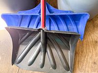 Close-up of blue and black shovel blades showing plastic material and wear