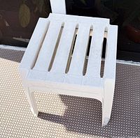 Full view of one white plastic stool on patio