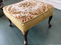 Oblique view showing full footstool, upholstery, and cabriole legs