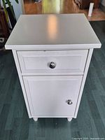 Front view showing drawer, cabinet door and knobs