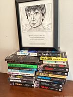 Stack of 20 Ian Rankin paperbacks with framed portrait print