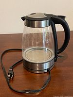 Electric glass kettle with cord and base visible