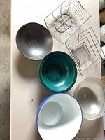 Overall view of four bowls and three wire racks on table