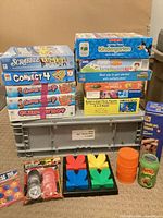 Full lot showing stacked boxed games, puzzles, wooden tumbling tower and loose accessories
