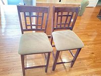 Two matching wood counter stools front view