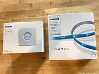 Front view of both sealed product boxes: Hue Bridge and Lightstrip Plus