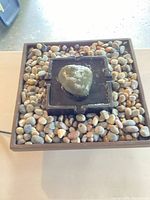 Top view of square resin fountain with center platform and river rocks