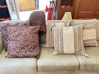All five throw pillows on sofa with plush blanket visible behind