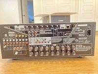 Rear view showing model label, speaker terminals, input/output ports, antennas attached