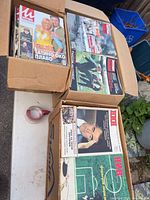 Three cardboard boxes filled with Ilustrovana Politika and NIN magazines