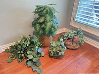 Group shot of all five artificial plants with baskets on wood floor
