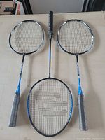 Three badminton rackets laid out showing full length, heads and grips