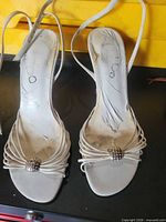 Top view of both sandals showing strappy design, rhinestone accents, and overall wear