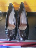 Pair of black patent round-toe pumps front view