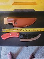 Knife and sheath laid out with tape measure showing overall size