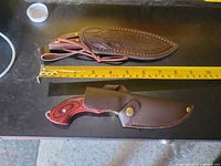 Two sheaths side by side, measuring tape shows length reference