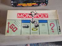 Box lid showing Monopoly branding and two dice resting on it