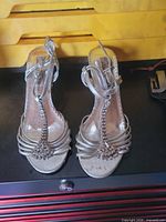 Top view of both silver strappy sandals showing rhinestone T-strap and general wear