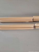 Close-up of two moulding strips, detailing groove profile and wood grain