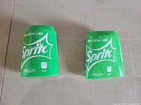 Front view of both green Sprite silicone can sleeves