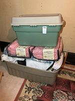 Stacked green tote on beige tote with two packaged Early’s comforters