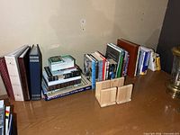 Overall lot showing books, three photo albums and wooden bookends on table