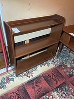 Front view of brown wooden bookshelf showing three shelves