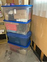 Stack of four clear totes filled with Christmas decorations