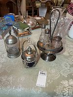 Overall lot showing cruet stand with bottles and two pickle castors on table