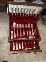 Closed and open view of chest showing two tiers of flatware