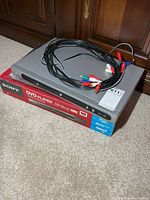 Sony DVD player box with Magnavox DVD player stacked on top and RCA cables