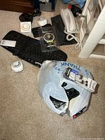 Lot overview showing keyboard, timers, corded phone, earbuds package, luggage scale, bag of cables.