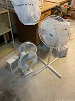 Group shot of pedestal fan, two table fans and heater