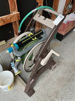 Side view of hose reel cart with hose, sprinkler, nozzle
