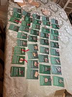 All 46 pewter ornaments on cards laid out on table