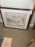 Full view of framed signed print leaning against wall