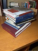 Stack of assorted hardcover military books on desk