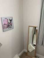 Mirror leaning against wall near canvas print