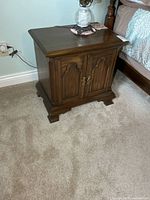 Nightstand beside bed showing size and style