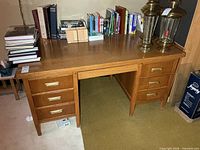 Front view showing full desk, six drawers, handles, overall condition