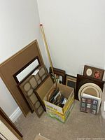 group of frames leaning against wall and in banana box