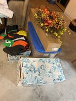 Stacked totes, black inflatable figure, autumn wreath on top of box