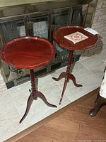 pair of matching wood pedestal side tables in front of fireplace