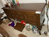 Front view of sideboard showing drawers, doors, legs, hardware