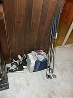 Full lot: skates, sports bag with hand grippers on top, four golf clubs
