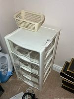 White plastic storage tower with basket on top