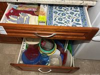 Top drawer showing oven mitt, pot holder, placemats
