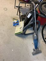 Shark stick vacuum, Kenmore canister vacuum, vacuum bag packs on floor