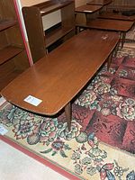 Top and legs of rectangular mid-century wooden coffee table showing finish and wear
