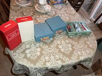 Overview showing two red boxes, two blue Madame Alexander boxes, one green tray with three Peggy Nisbet boxes